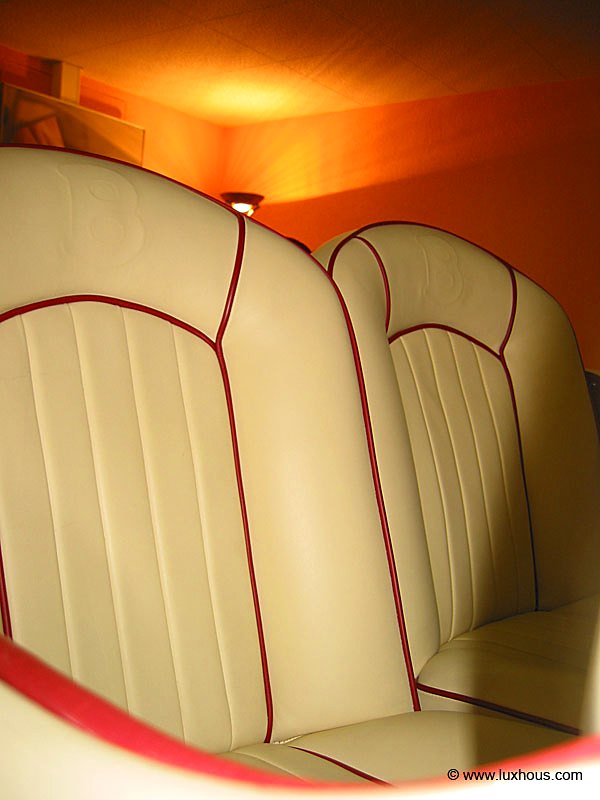 Banquette arrière en cuir clair à passepoil rouge, gaufrage